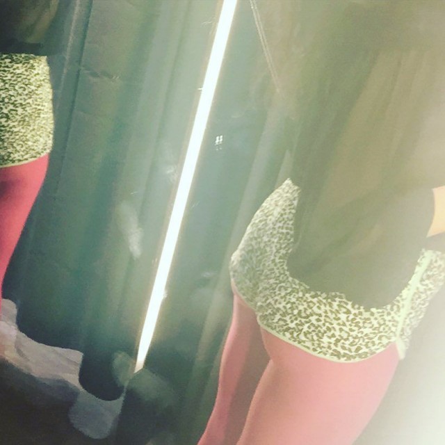 Piernas con medias rosas y ropa de estampado de leopardo junto a una tira de luz vertical
