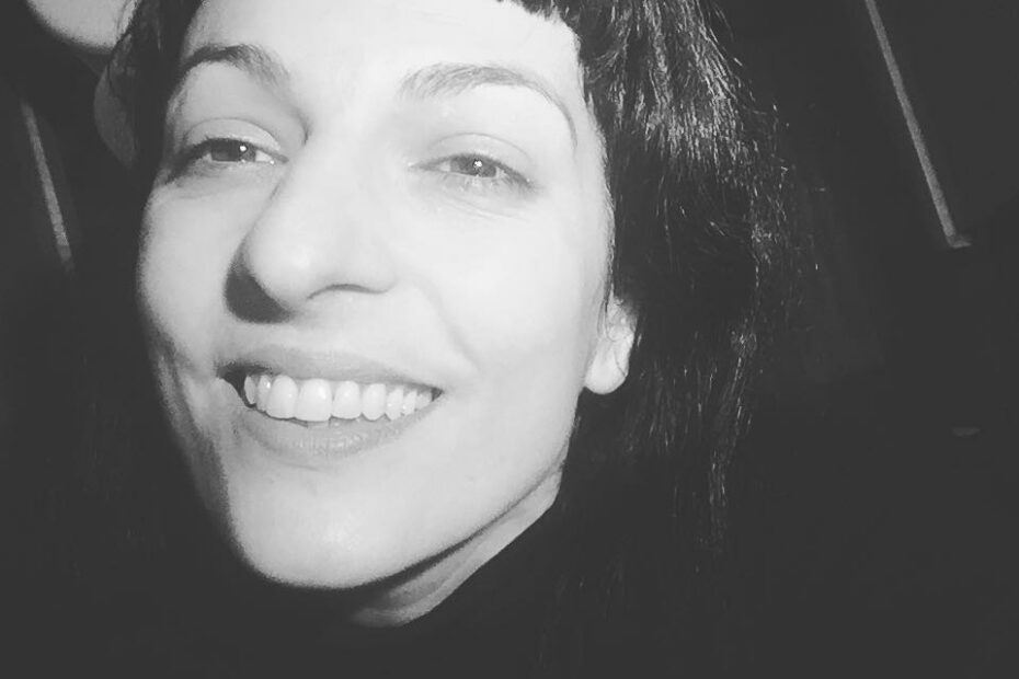 Autorretrato sonriente en blanco y negro, con flequillo y melena oscura