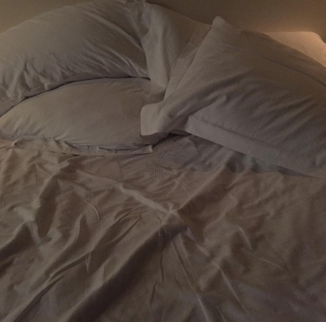 Cama deshecha con almohadas y sábanas blancas