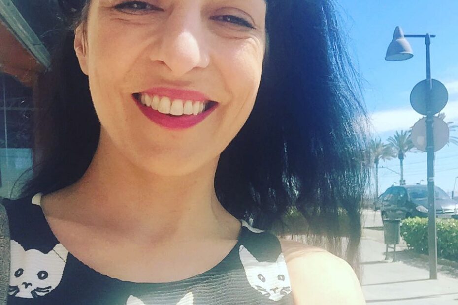 Selfi de Roser Amills sonriendo al sol, con una farola y el mar al fondo, en Vilassar de Mar