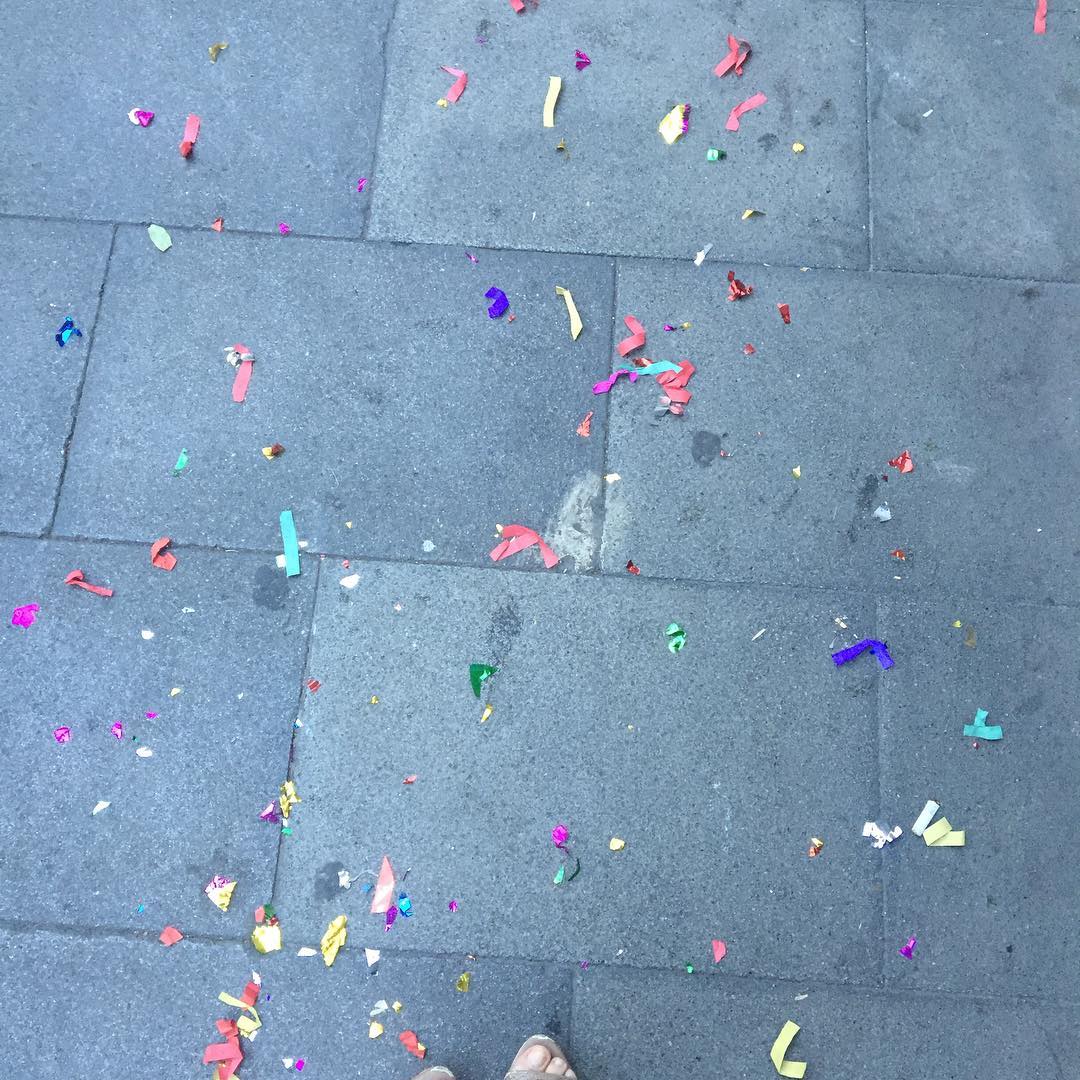 Confeti de colores esparcido sobre las baldosas grises de una acera