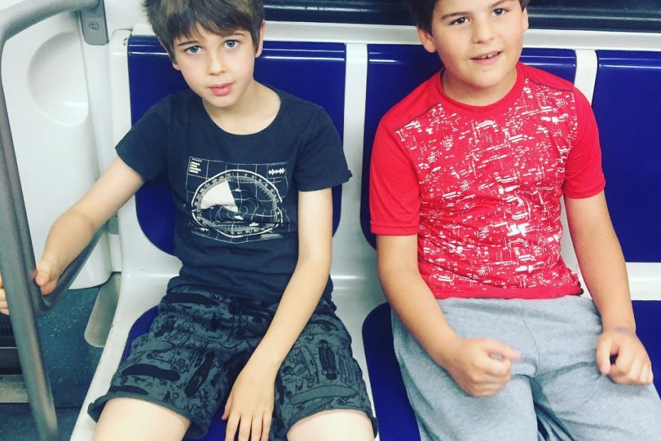 Juan, el hijo pequeño de roser amills, y Marlowe, camino del cumple, un poco dormidos