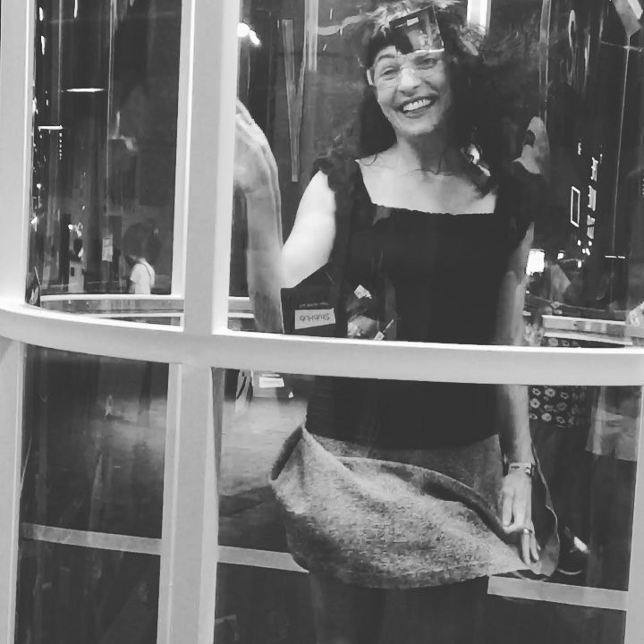 Roser Amills sonriente dentro de una cabina acristalada, en blanco y negro