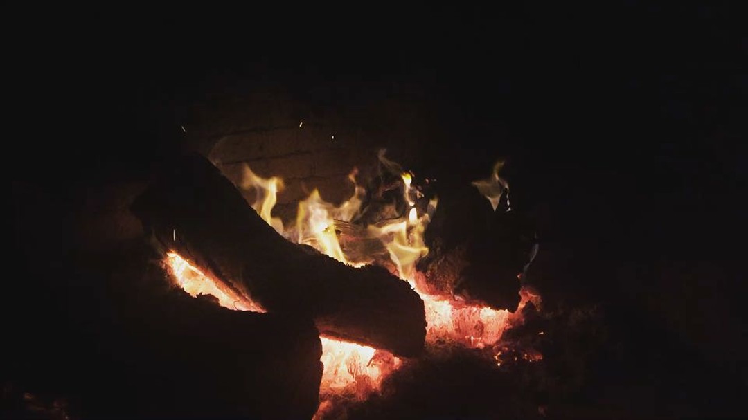 Brases i flames d’una llar de foc en la foscor