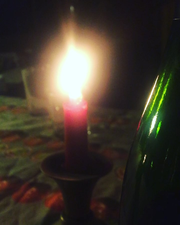 Vela roja encendida junto a una botella, en la noche de Nochebuena de 2017