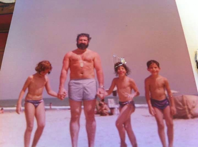 Roser Amills de niña con su pdre y hermanos en la playa