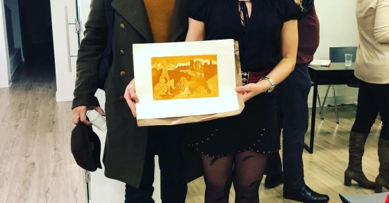 Roser Amills agradece a Juan Melénchon el regalo de Diego Scar Cáceres, de BBROMURO 2018, que ya forma parte de su salón.