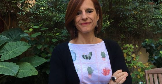 Retrato de Anna Manso con los brazos cruzados ante unas plantas