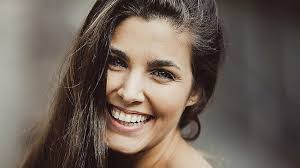 Retrato de la actriz Aida Flix sonriendo, con el pelo oscuro suelto