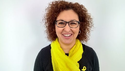 Retrato de Ainoa Olza, con gafas, pelo rizado y fular amarillo