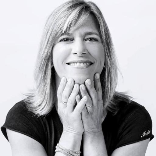 Retrato en blanco y negro de Ana Cuatrecasas sonriendo, con la cara apoyada en las manos