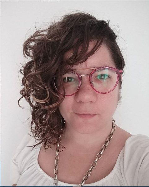 Retrato de Anna Amat con gafas rosas y pelo rizado