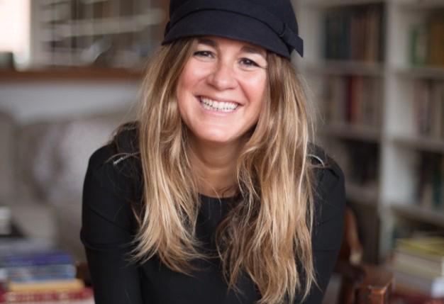 Retrato de Iolanda Batallé, con gorra negra, en una biblioteca