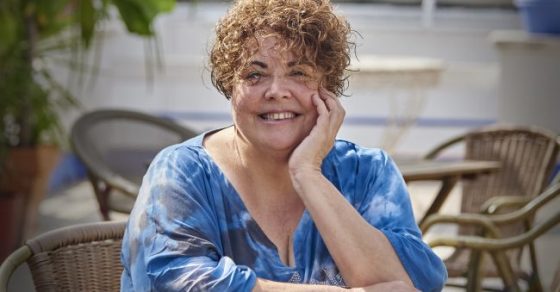 Retrato de la poeta Marta Pérez Sierra sentada a una mesa de terraza