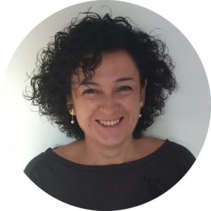Retrato circular de Montse Ferrer, de pelo rizado oscuro, sonriente