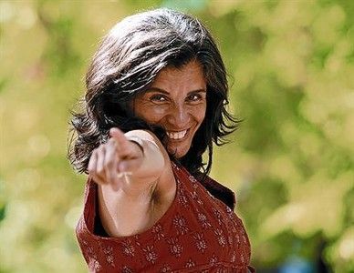 Nora Almada assenyala la càmera somrient, a l'aire lliure i amb vestit vermell