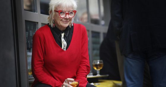Retrato de la periodista Núria Ribó con gafas rojas y jersey rojo