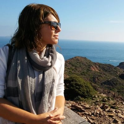 Olga Samper, con gafas de sol y fúbar, mira al mar desde un acantilado