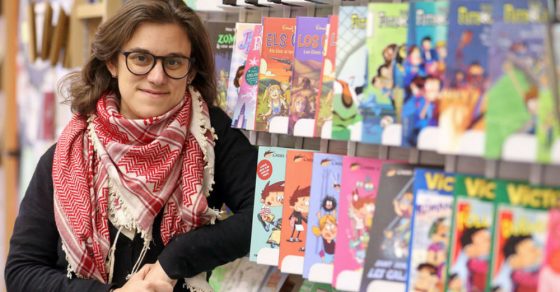 Paula Jarrín, con gafas y pañuelo palestino, ante un expositor de cómics