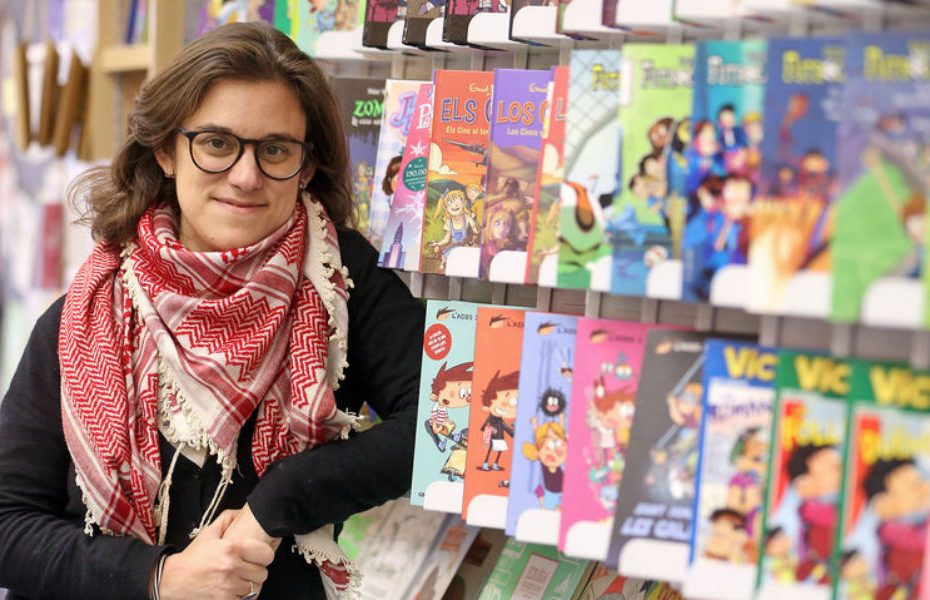 Paula Jarrín, con gafas y pañuelo palestino, ante un expositor de cómics