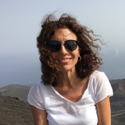Silvia Hinojosa sonríe con gafas de sol y camiseta blanca en lo alto de una montaña