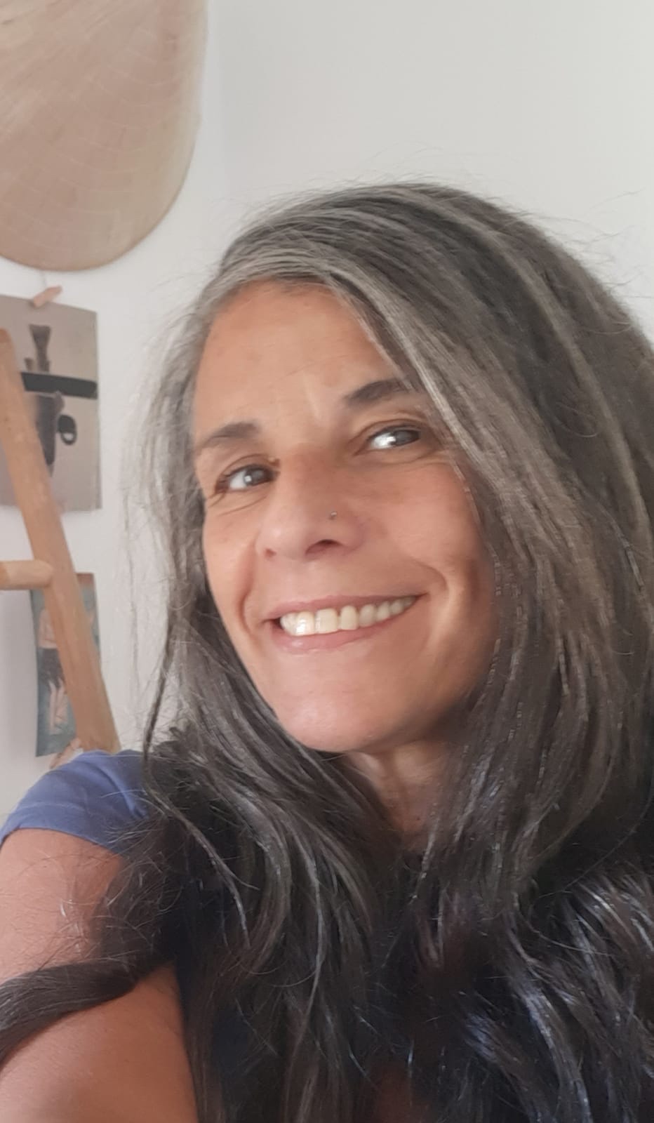 Autoretrat de Nora Almada, somrient, amb els cabells llargs i canosos