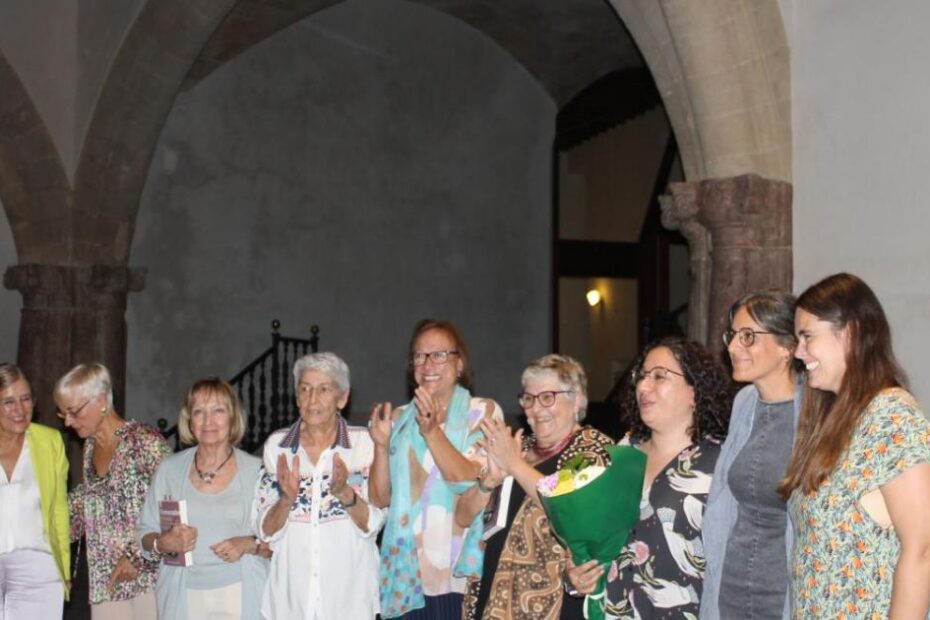 Grup de poetes aplaudint al pati de Can Balaguer, a Palma, després de la presentació de «Flamarades sortiran»