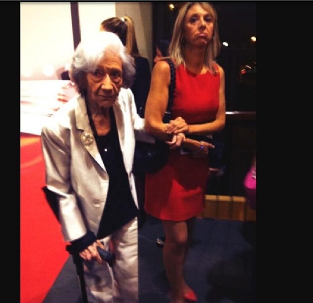 Ana María Matute con bastón y chaqueta blanca en la gala del Premio Planeta 2013, junto a una mujer de rojo