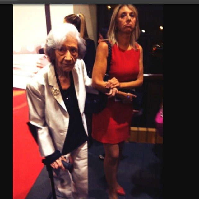 Ana María Matute con bastón y chaqueta blanca en la gala del Premio Planeta 2013, junto a una mujer de rojo