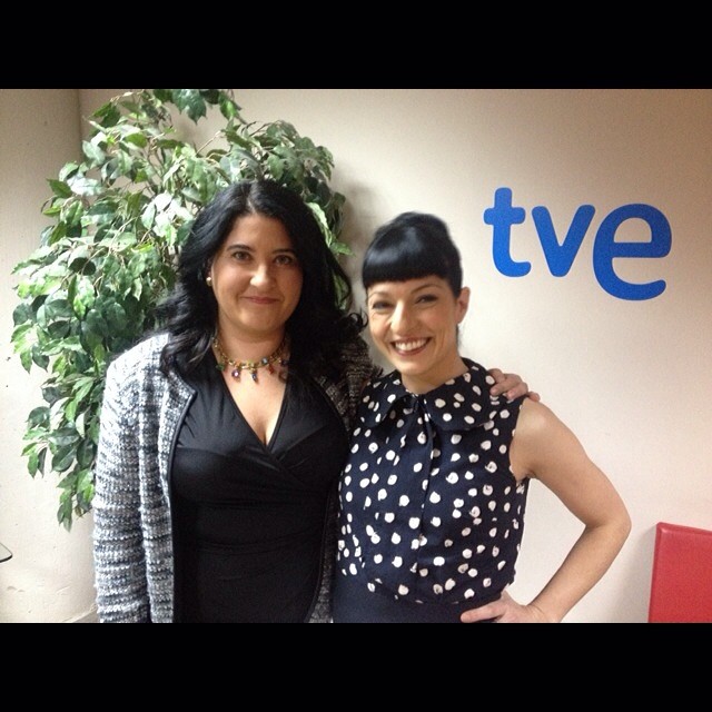 Carmen García y Roser Amills, con vestido de lunares, de pie ante el logo de TVE