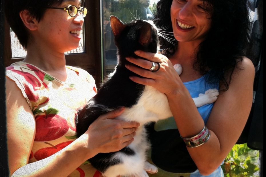 Naoko, esposa de Fernando Sánchez Dragó, y Roser Amills sonríen con un gato blanco y negro