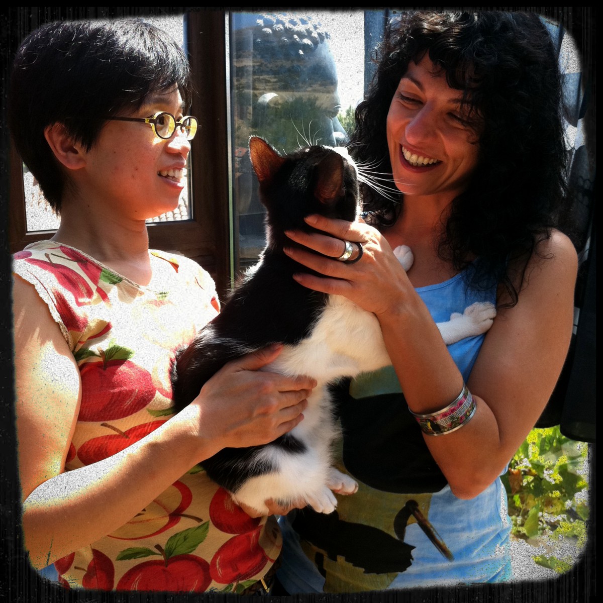 Naoko, esposa de Fernando Sánchez Dragó, y Roser Amills sonríen con un gato blanco y negro