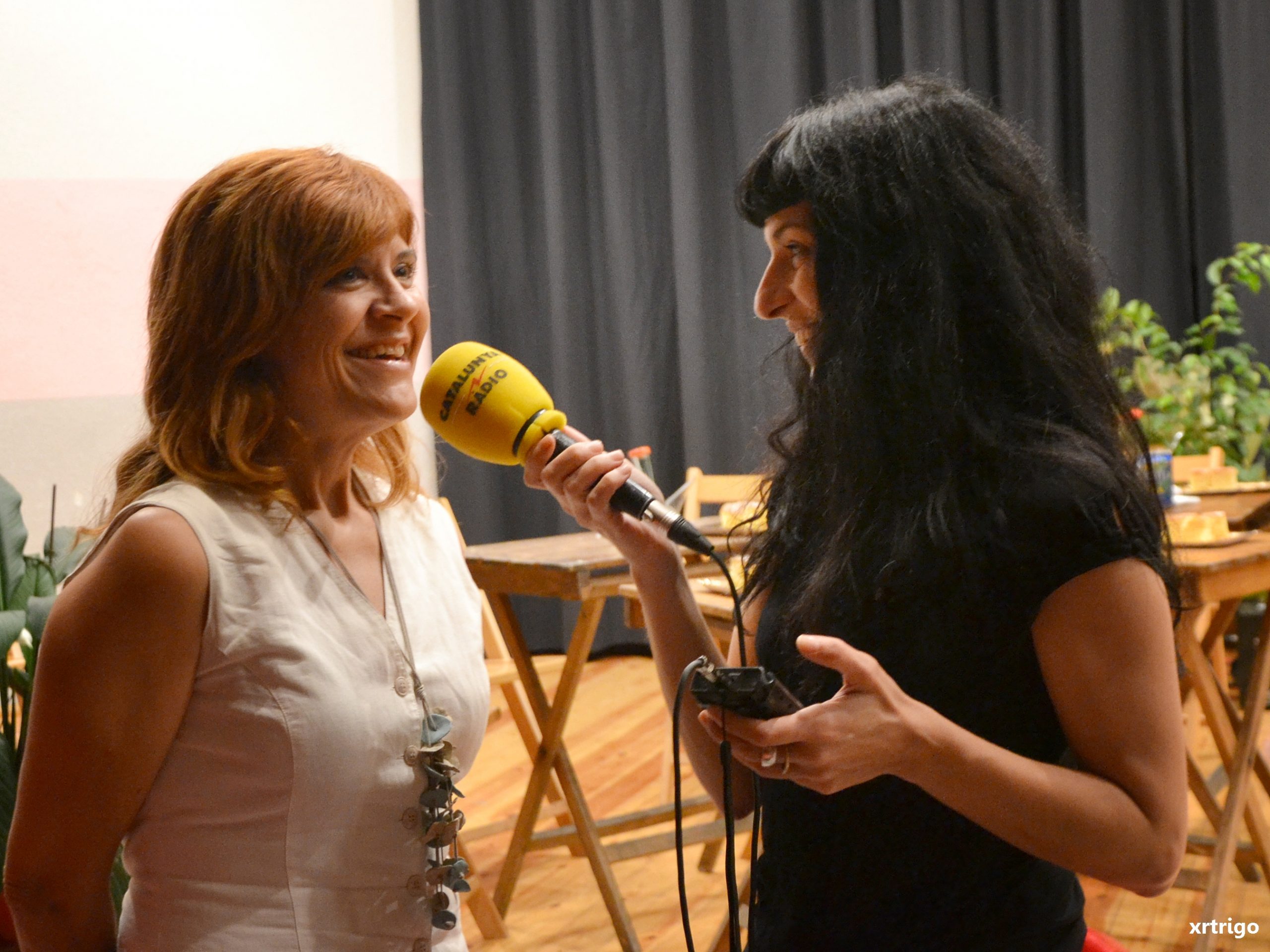 Coia Valls habla al micrófono amarillo de Catalunya Ràdio que sostiene Roser Amills