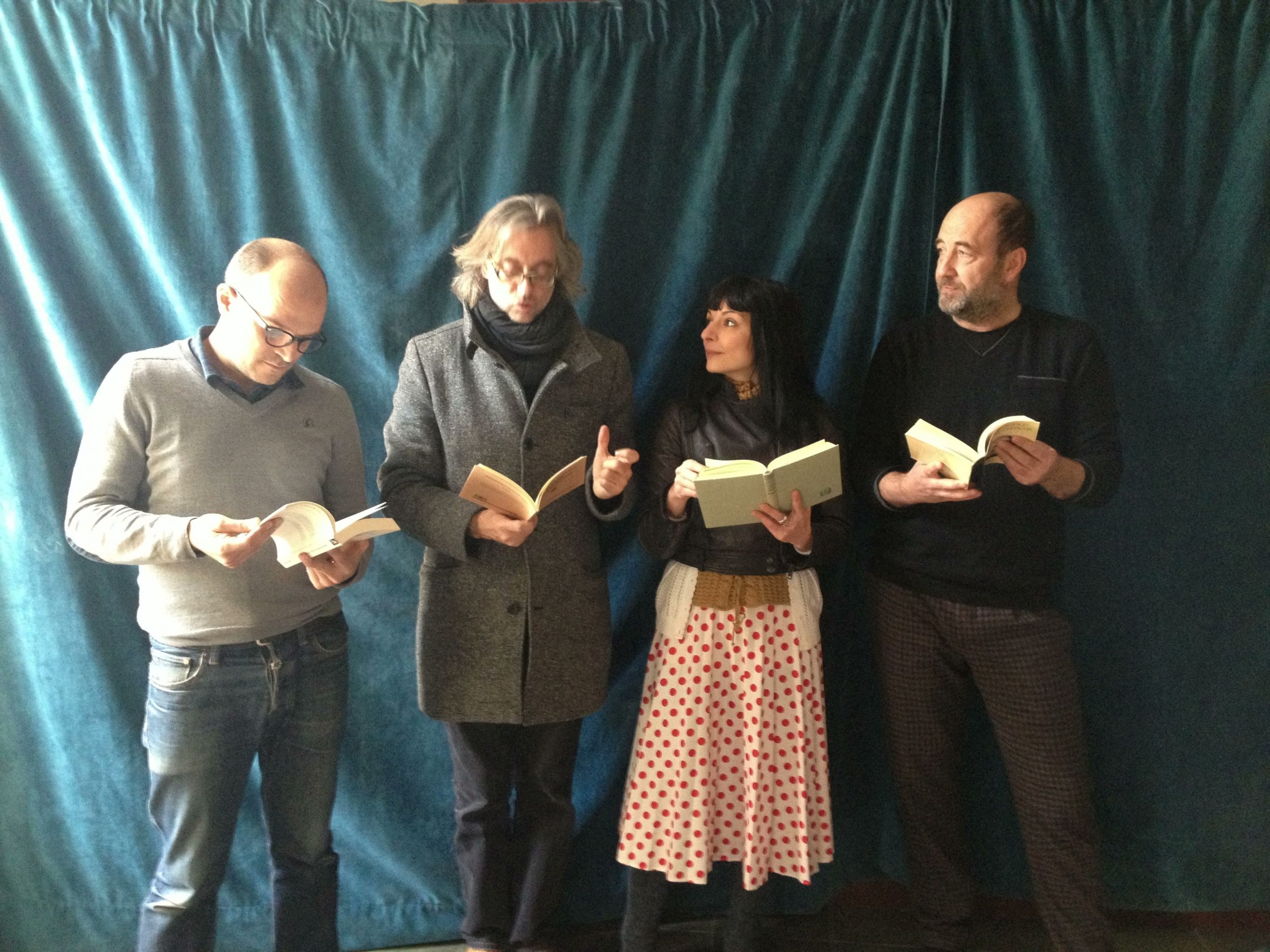 Cuatro personas leen libros ante un telón azul: Roser Amills, Víctor Amela, Emili Manzano y otro miembro del equipo