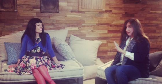 Roser Amills y Marta Arasanz sentadas en sofás en un local con pared de madera