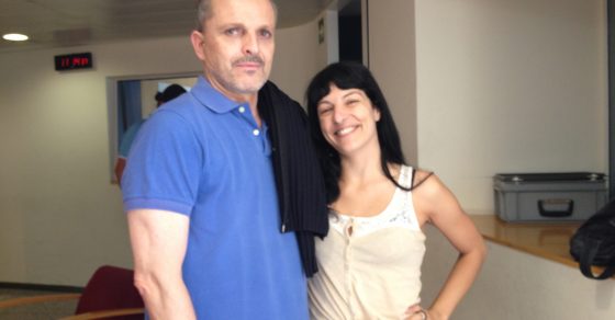 Roser Amills y Miguel Bosé, con polo azul, en una sala