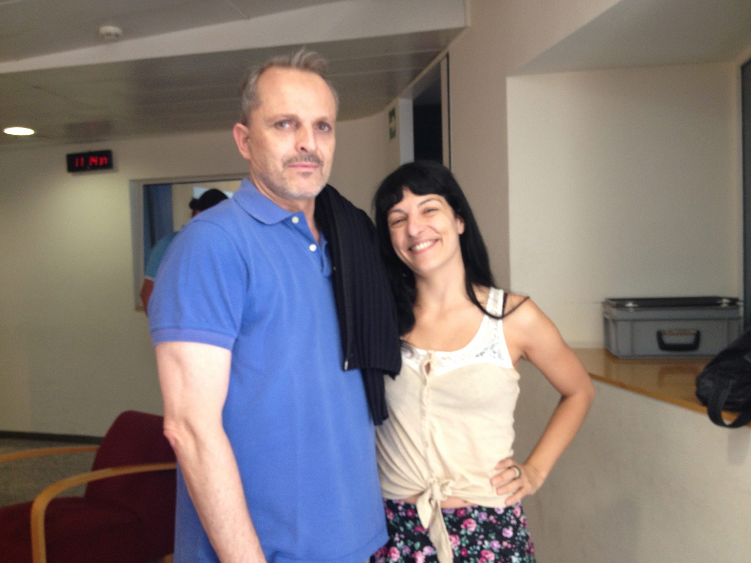 Roser Amills i Miguel Bosé, amb polo blau, en una sala