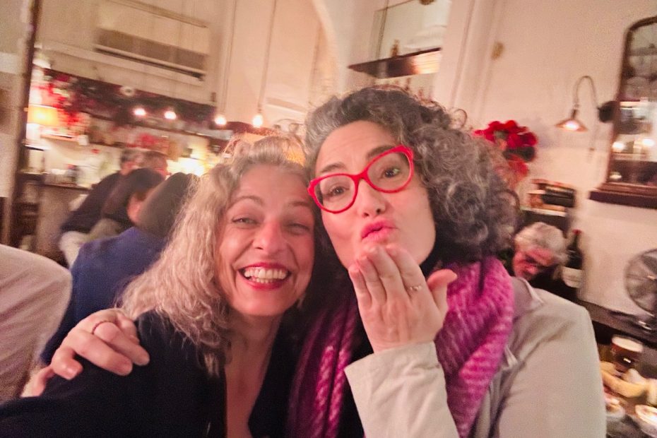 Roser Amills y Lucía Salcedo, con gafas rojas, sonríen juntas en un local