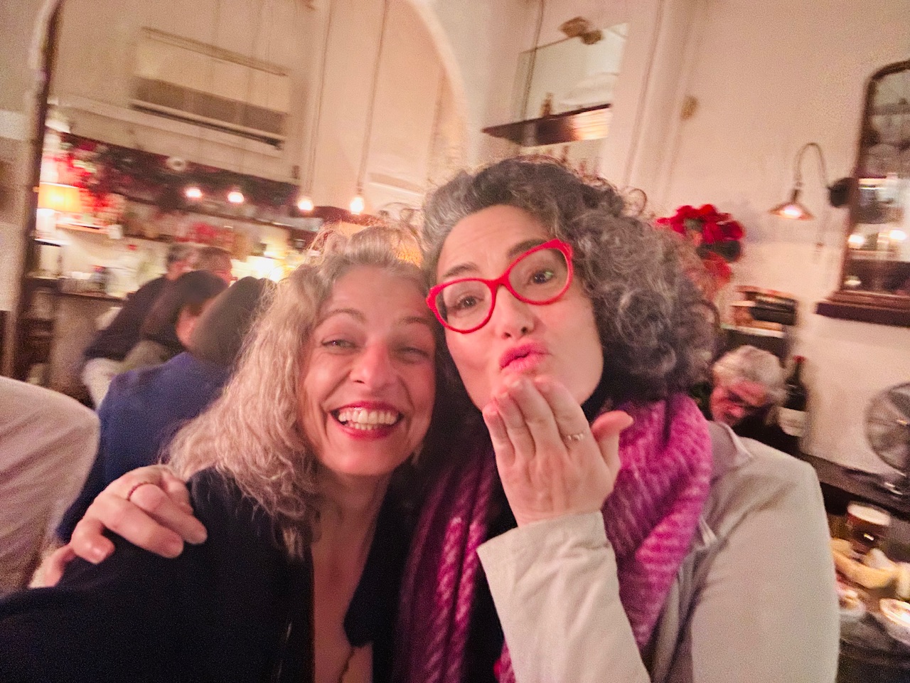 Roser Amills y Lucía Salcedo, con gafas rojas, sonríen juntas en un local