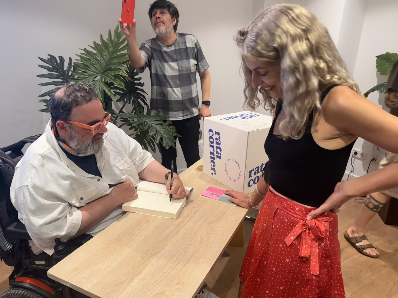 Bob Pop, sentado, firma un libro ante Roser Amills en una librería de Palma