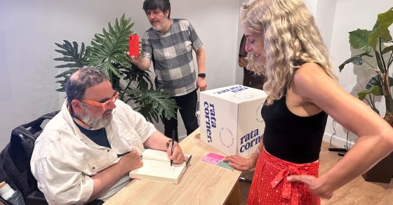 Roser Amills, con falda roja, conversa con Bob Pop mientras él firma libros en Palma