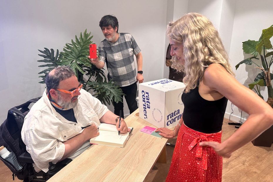 Roser Amills, con falda roja, conversa con Bob Pop mientras él firma libros en Palma