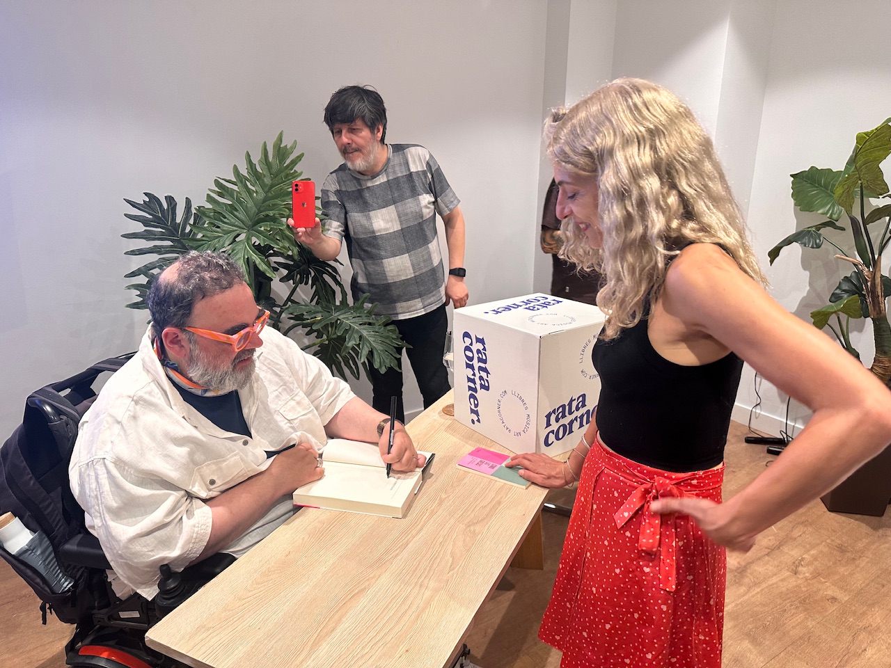 Roser Amills, con falda roja, conversa con Bob Pop mientras él firma libros en Palma