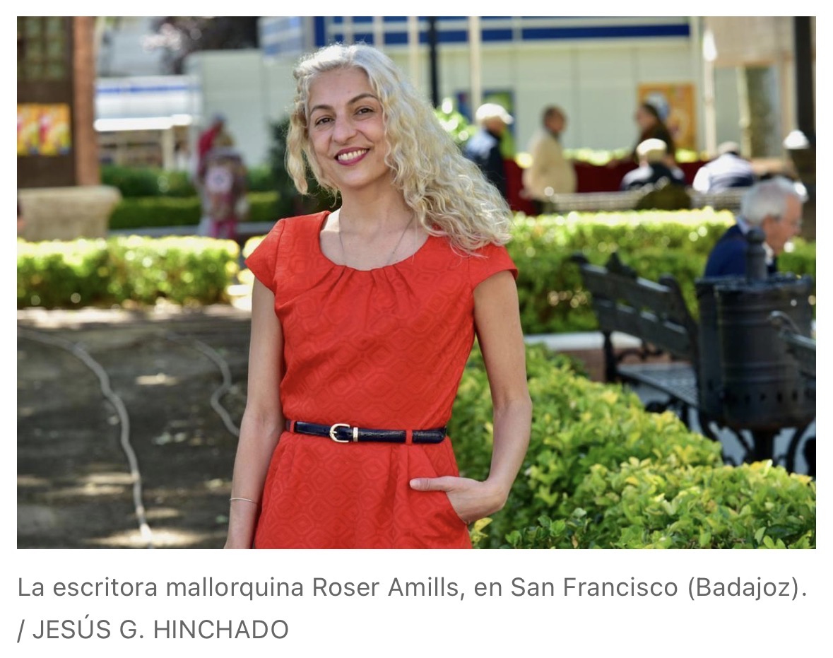 Roser Amills, con vestido rojo, sonriente en el parque de San Francisco de Badajoz durante la Feria del Libro