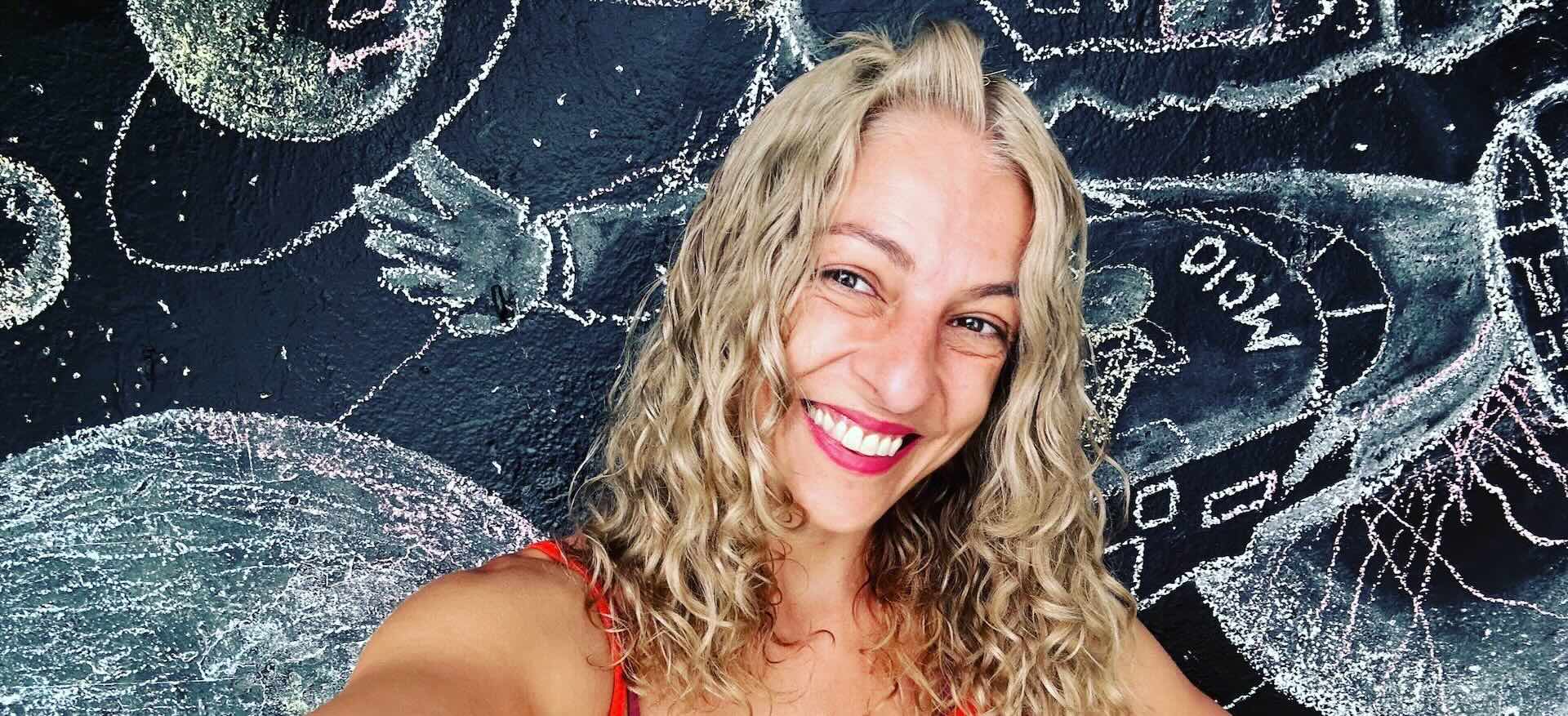 Roser Amills sonriendo frente a un mural de tiza