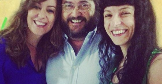 Roser Amills sonríe junto a una mujer y un hombre con barba ante un cartel de Catalunya Ràdio