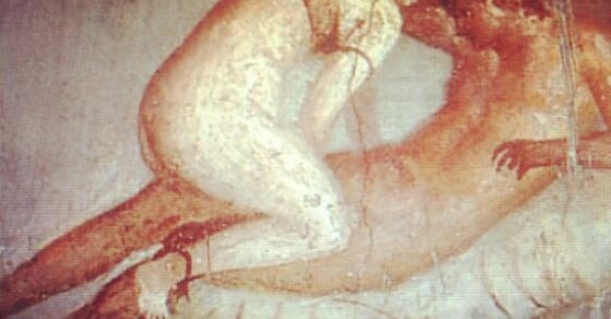 Pintura mural antigua de dos cuerpos desnudos abrazados sobre un lecho