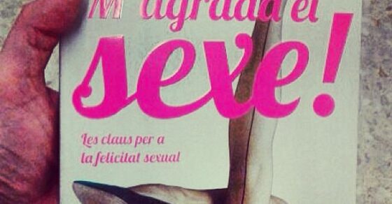Una mano sostiene un ejemplar de M'agrada el sexe!, de Roser Amills