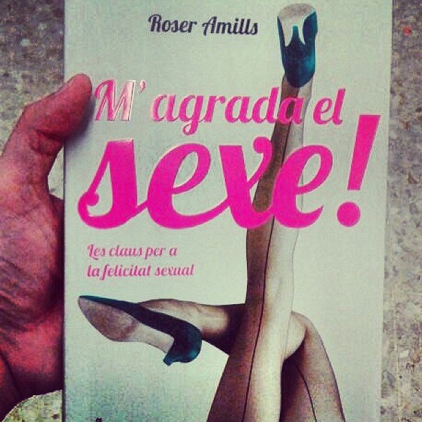 Una mano sostiene un ejemplar de M'agrada el sexe!, de Roser Amills