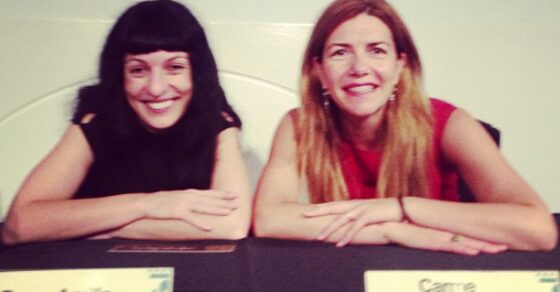 Roser Amills y Carme Sánchez sentadas a una mesa con tarjetones con sus nombres, en Cerdanyola, septiembre de 2013